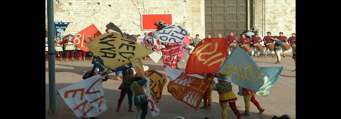 Alcuni sbandieratori in Piazza Grande a Gubbio che si esibiscono con le bandiere